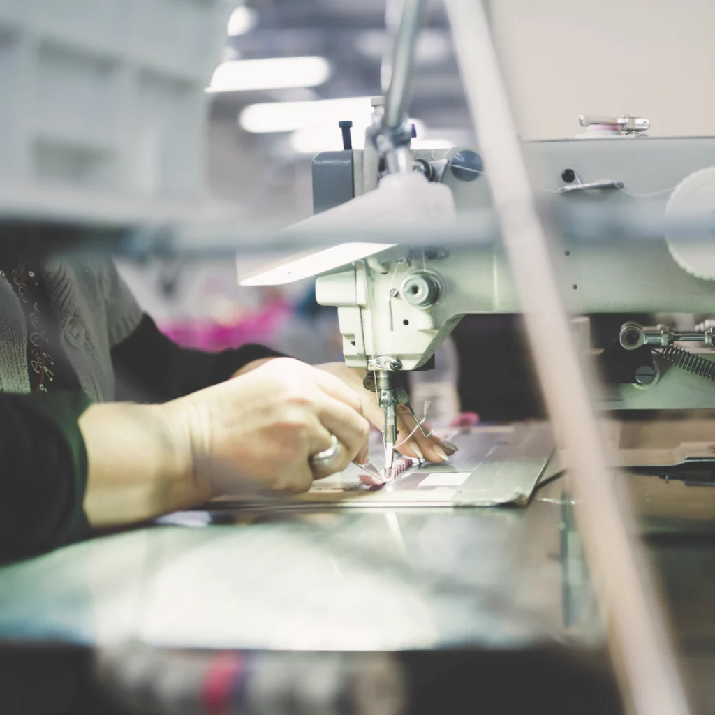 Couturière dans une usine sur une machine à coudre industrielle